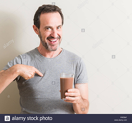 senior-man-drinking-chocolate-milk-shake-with-surprise-face-pointing-finger-to-himself-P9FBNF